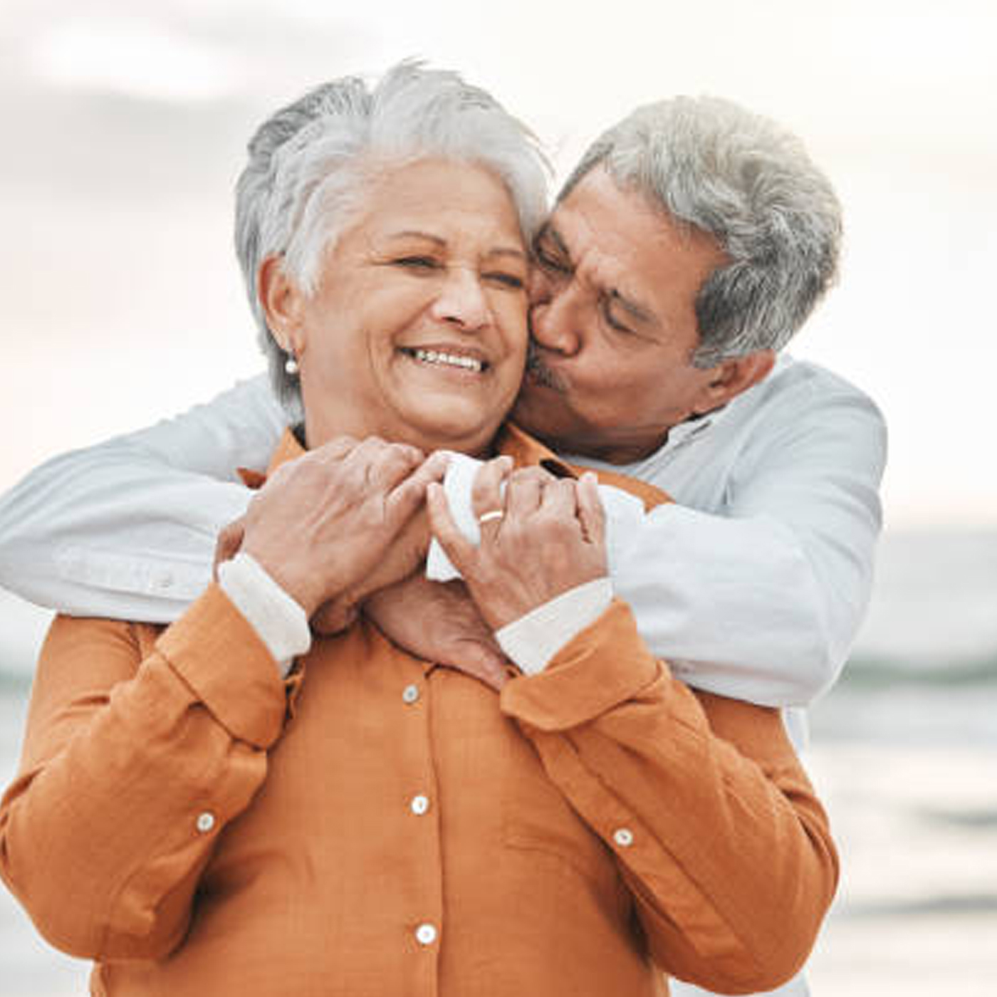 hispanic latino elderly couple hugging and kissing