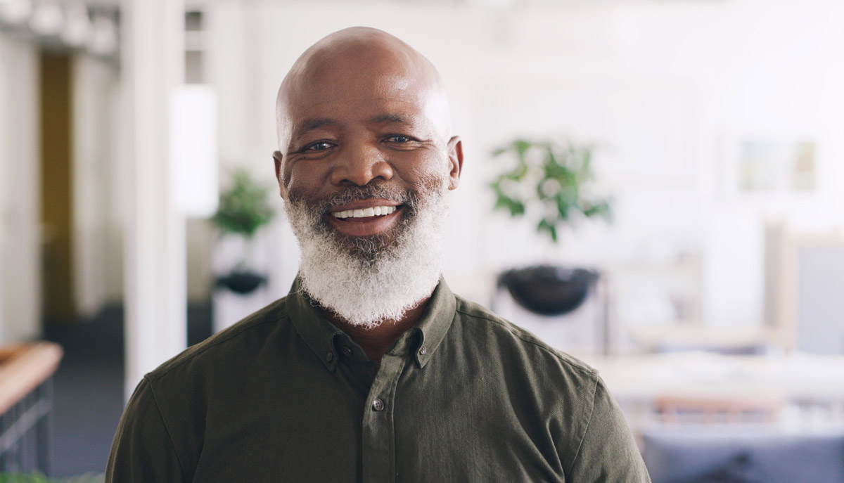 Older black man with white beard looking directly at the camera and smiling