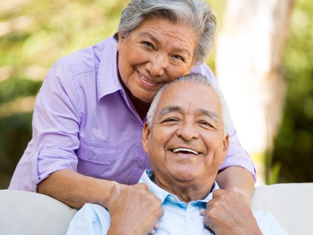 Older LatinX Couple Hugging and looking into the camera